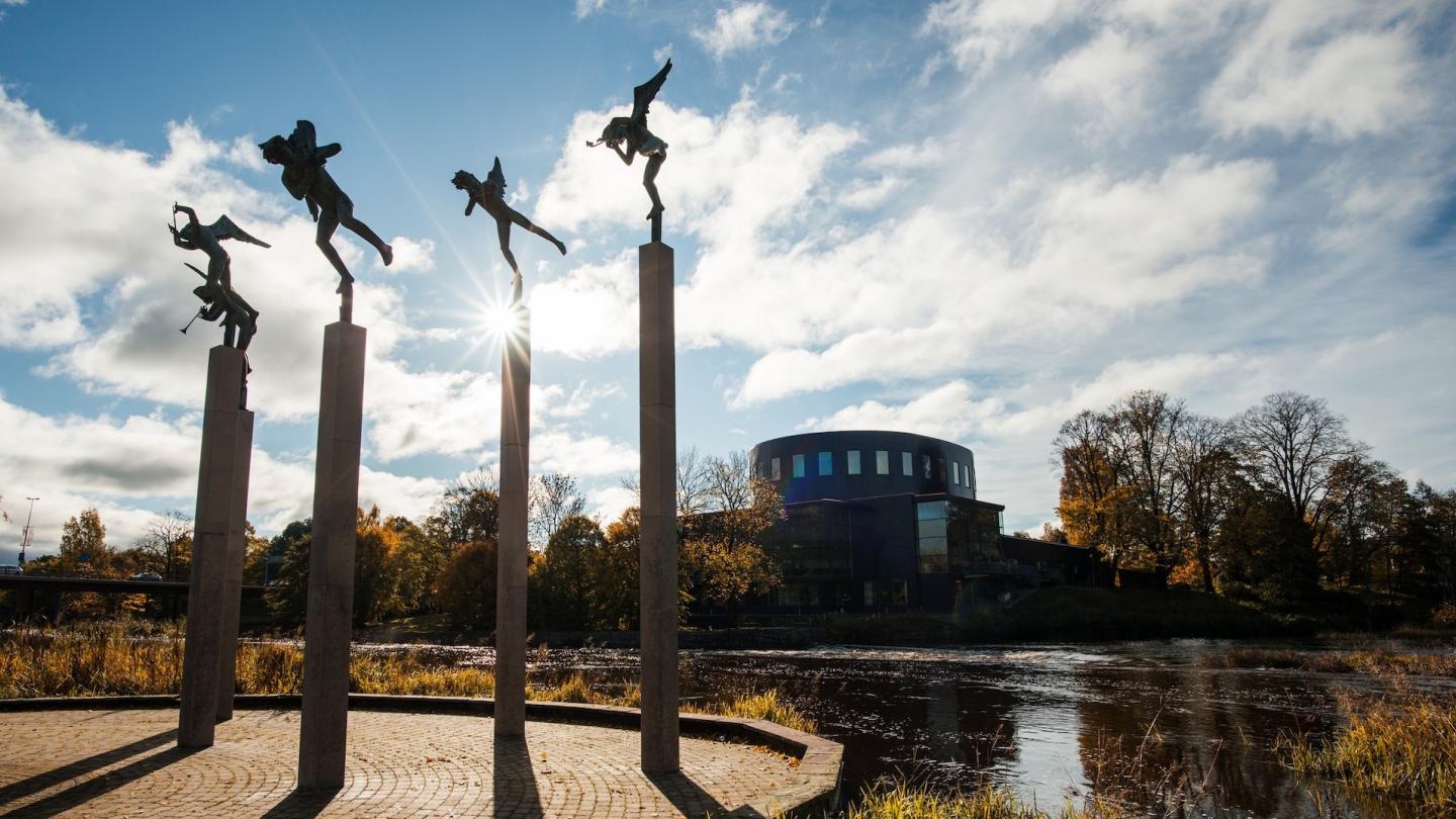 Den runda byggnaden Gävle konserthus med vatten och statyerna Milles änglar i förgrunden en höstdag.