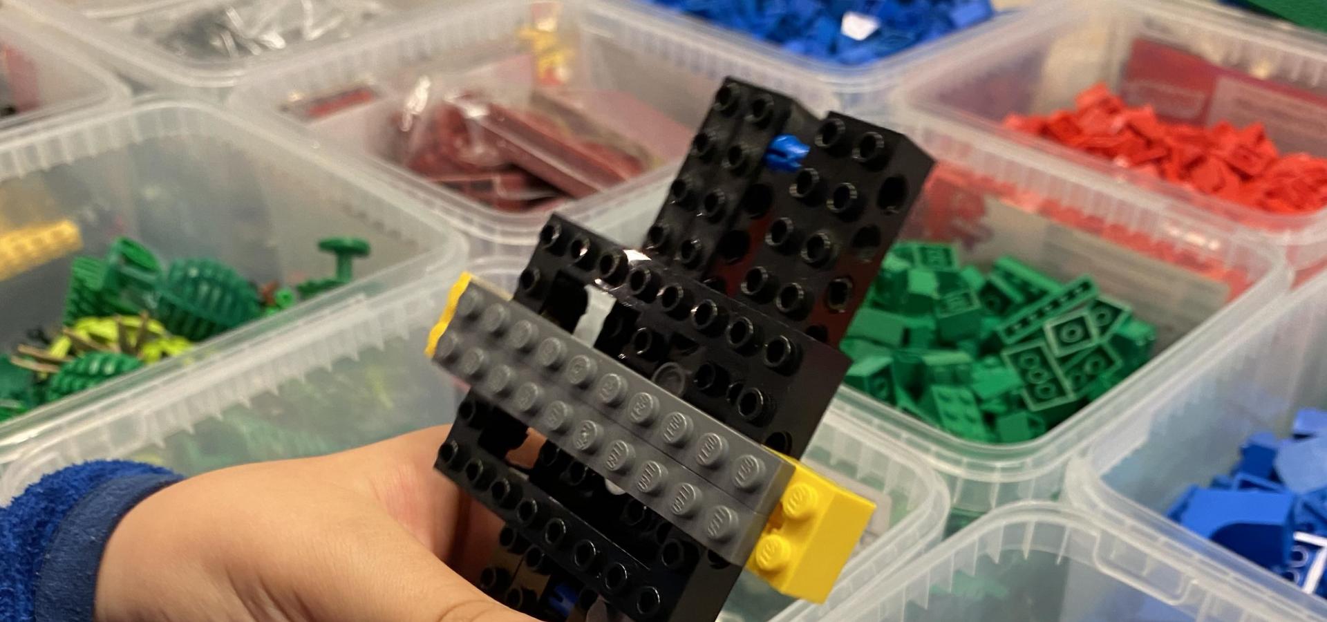 Händer som bygger med lego.
