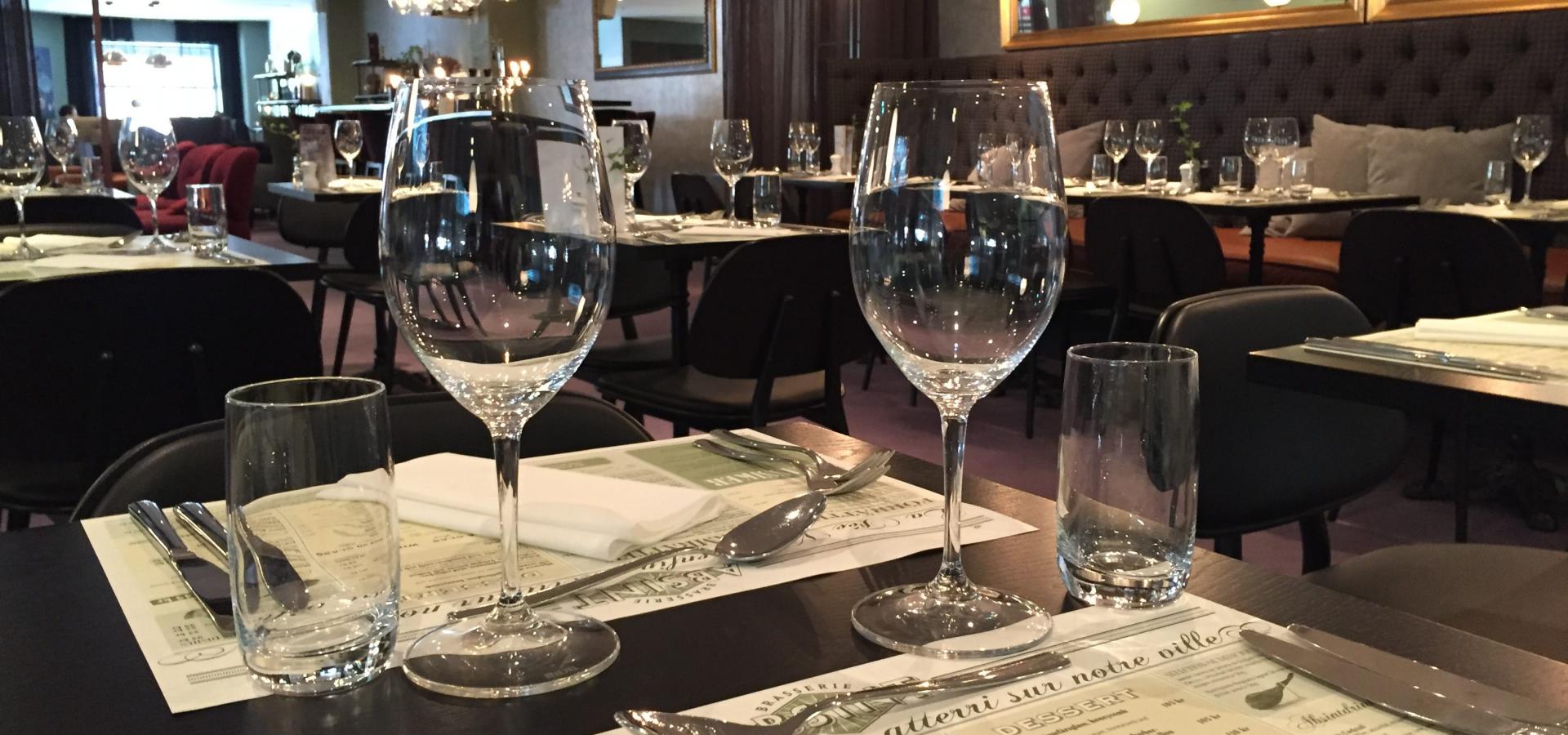 En restaurang med några bord och vin glas i förgrunden - Foto Gävle City