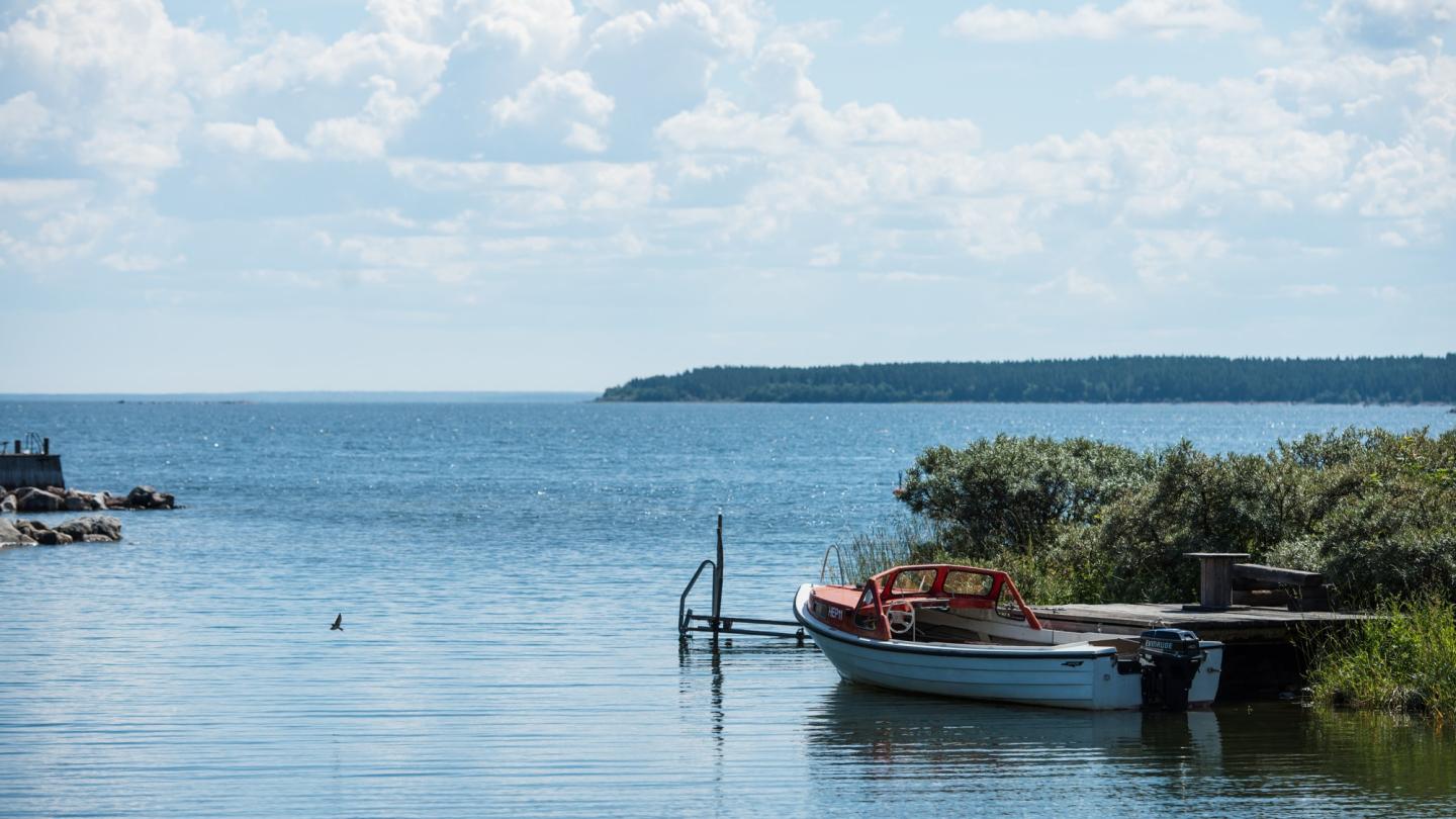 Havet vid Bönan på en solig sommardag. Liten motorbåt vid pir till höger i bild. Foto Daniel Bernstål.