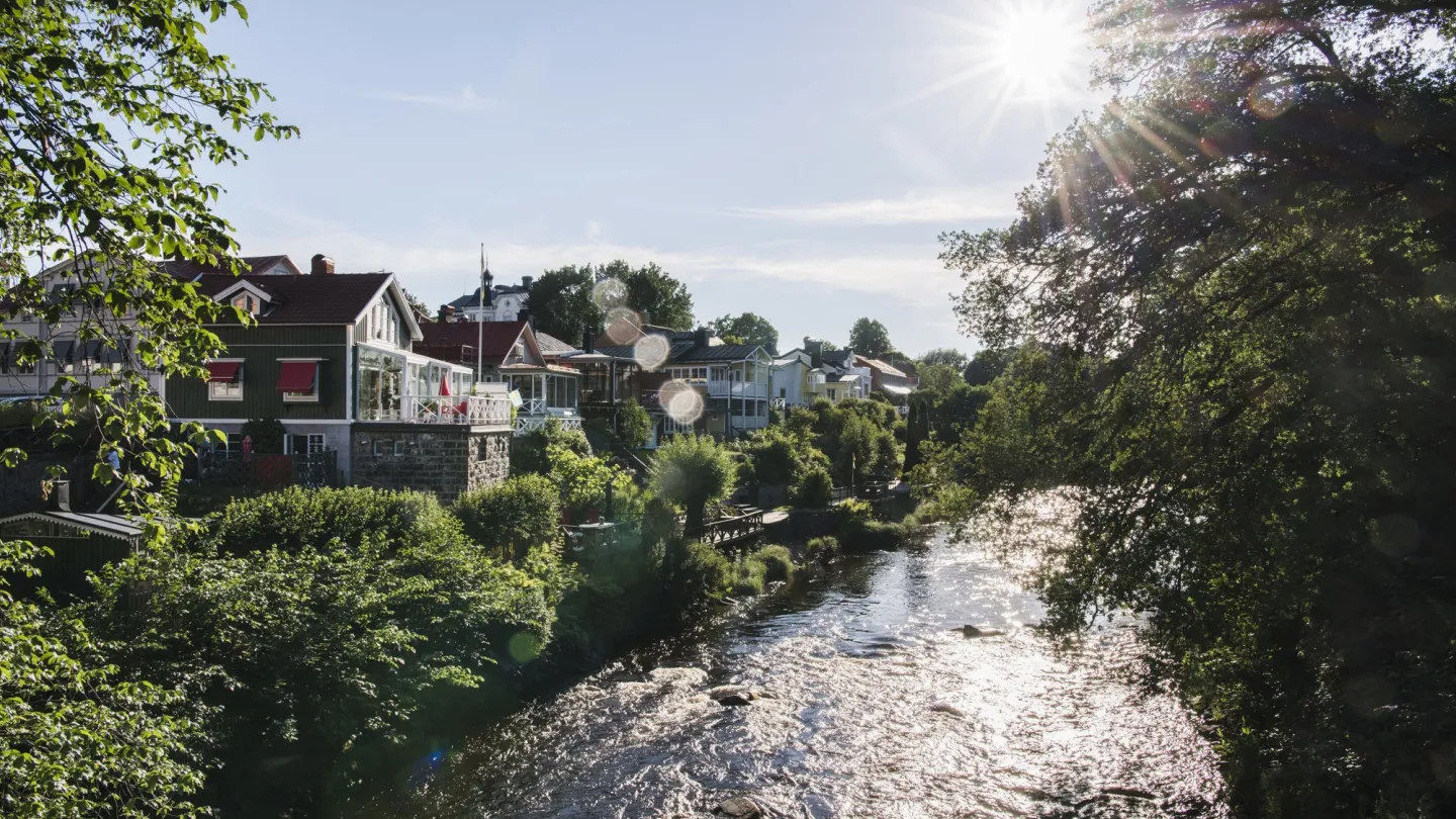 Gavleån rinner mellen hus i grönskan