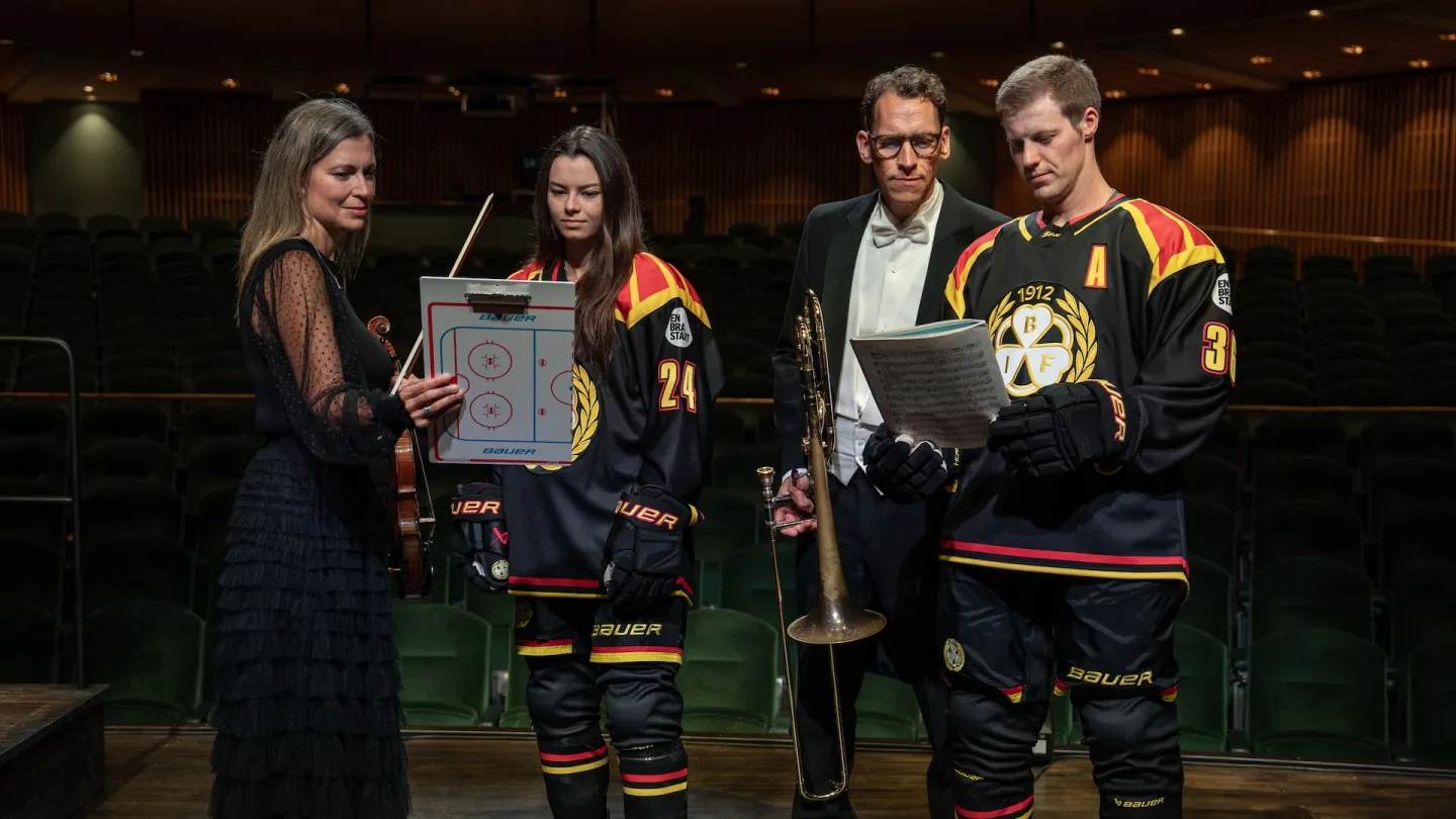 Hockeyspelare tittar på noter tillsammans med dirigenter