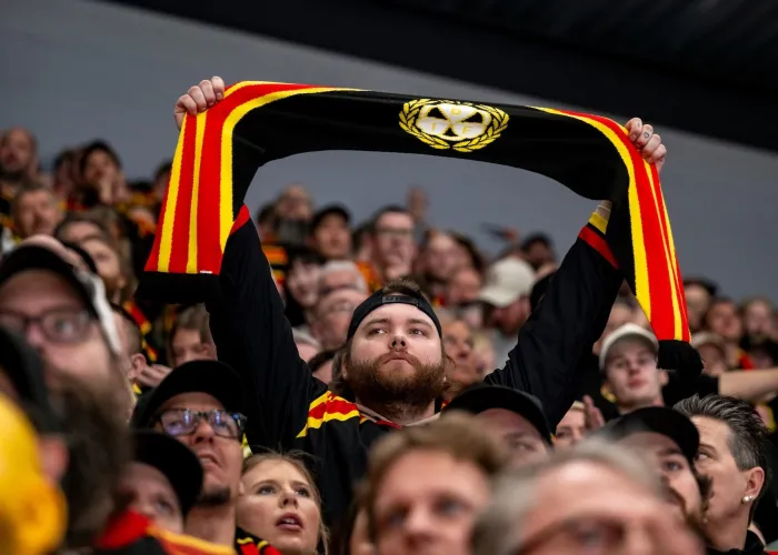 Hockeysupporter i publikhav håller upp Brynäs halsduk 