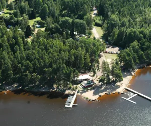 CampRestLucht3 - Foto Visit Hedesunda Drönarvy över skog, strand och bryggor
