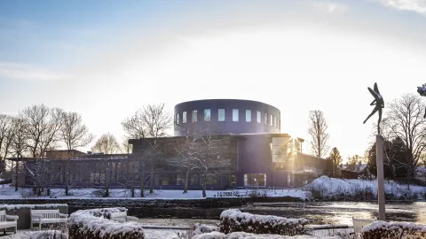 Cylinderformad byggnad vid vatten vintertid