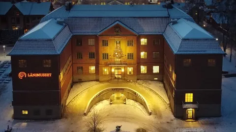 Stor tegelbyggnad inbäddad bland gröna träd