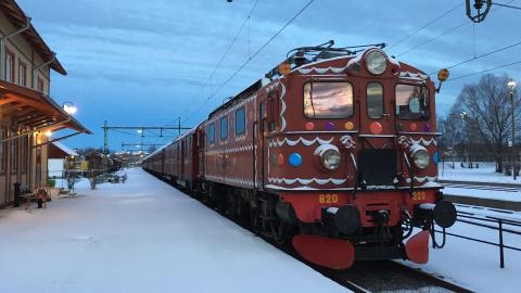 Tåg målat som ett pepparkakståg i skymningen