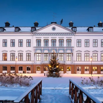 Ståtlig herrgård vid vatten en fin höstdag 