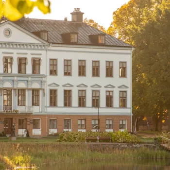 Ståtlig herrgård vid vatten en fin höstdag 