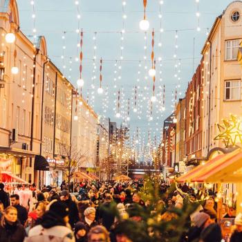 Julmarknad på en gågata i Gävle city en vinterkväll med massor av folk och julbelysning